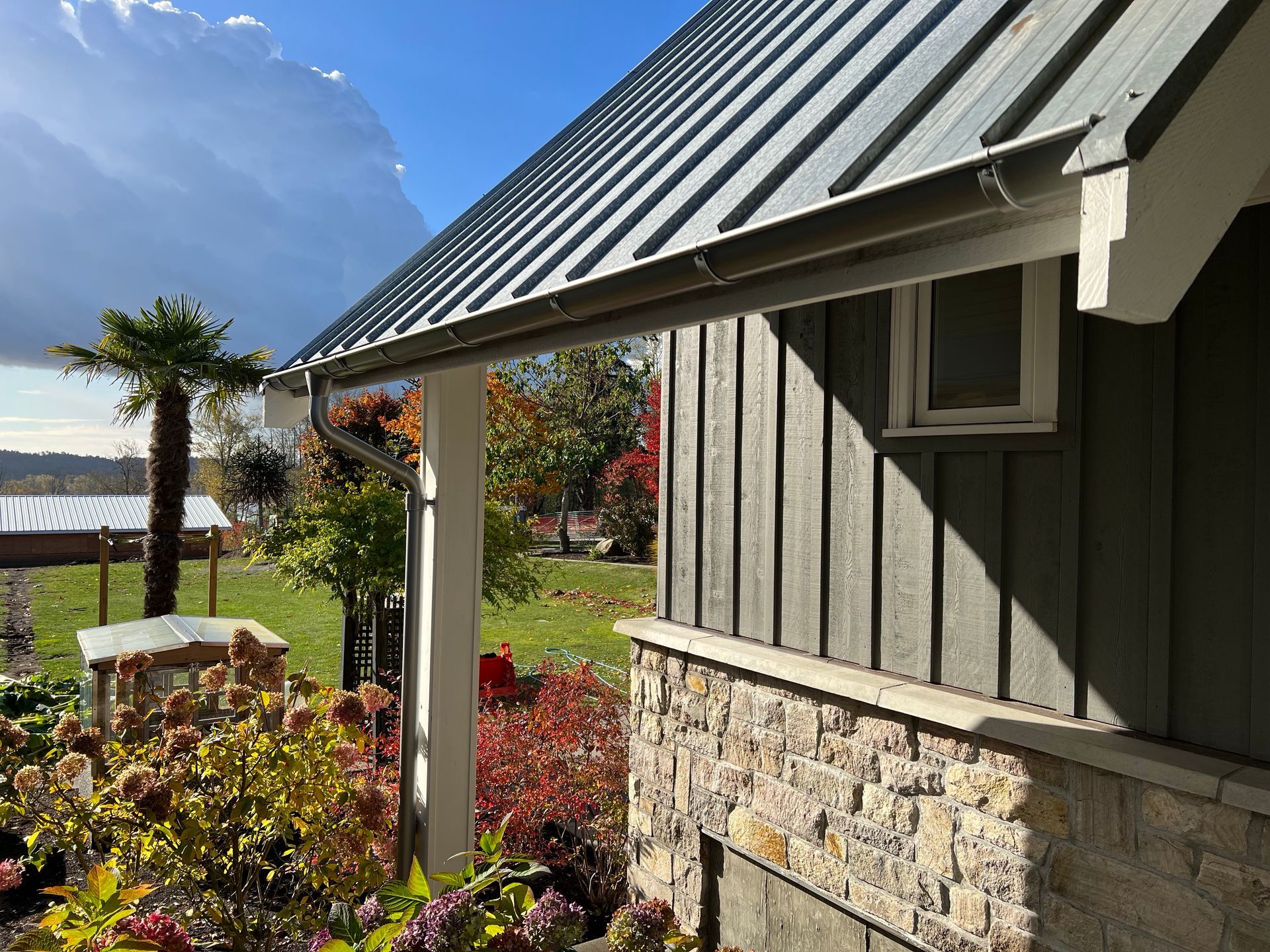 A house with a metal roof and a stone wall