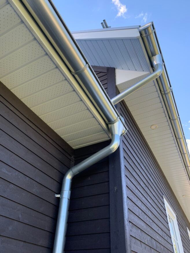 A close up of a gutter on the side of a house