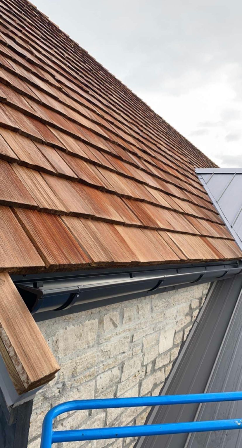 A close up of a wooden roof on a brick building.