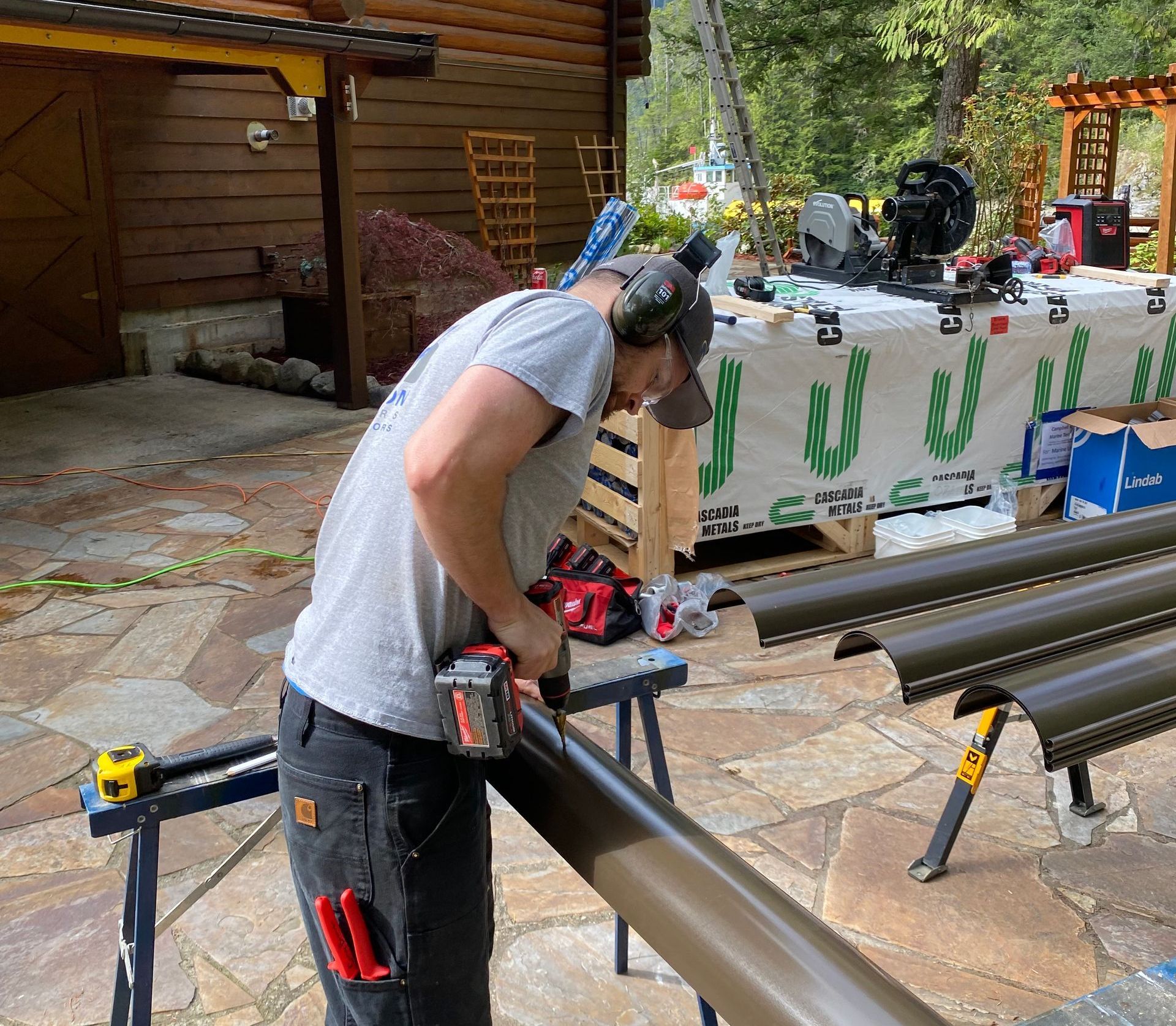 A man wearing headphones is working on a piece of metal
