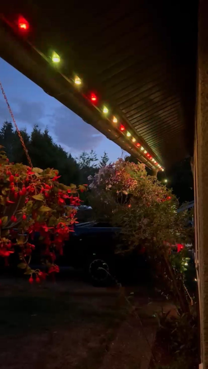 A porch with christmas lights on it at night.