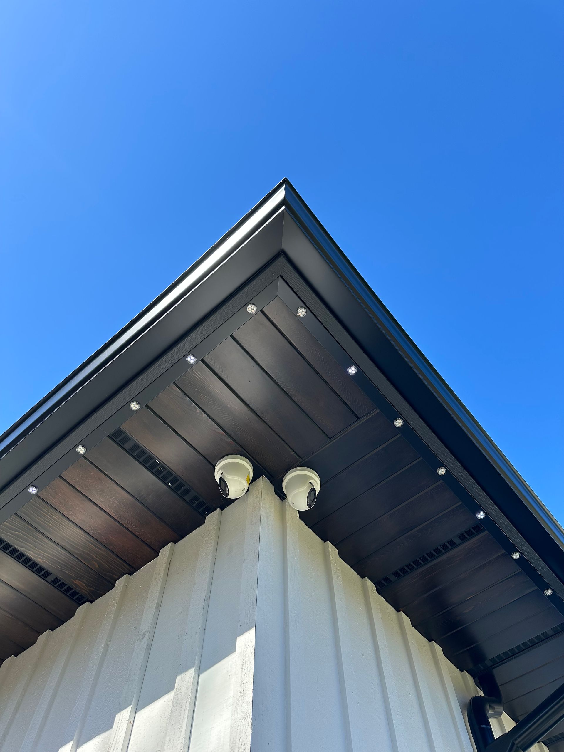 Looking up at the roof of a house with a blue sky in the background.