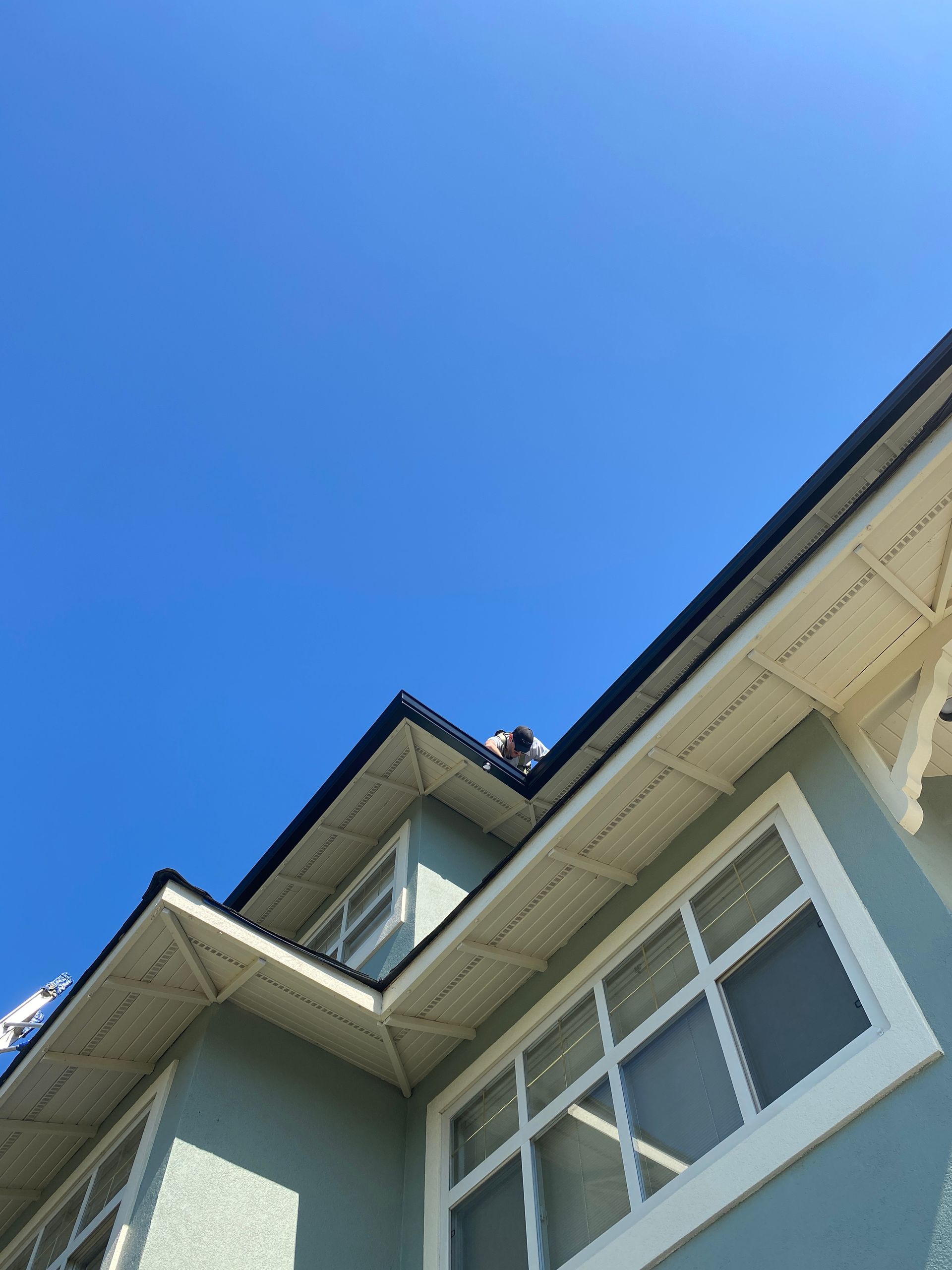 Looking up at the roof of a house with a blue sky in the background