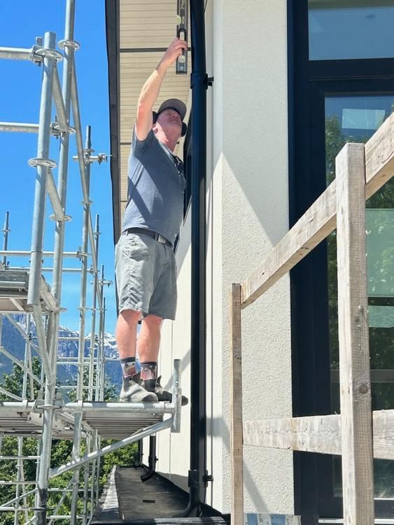 A man is standing on a scaffolding on the side of a building