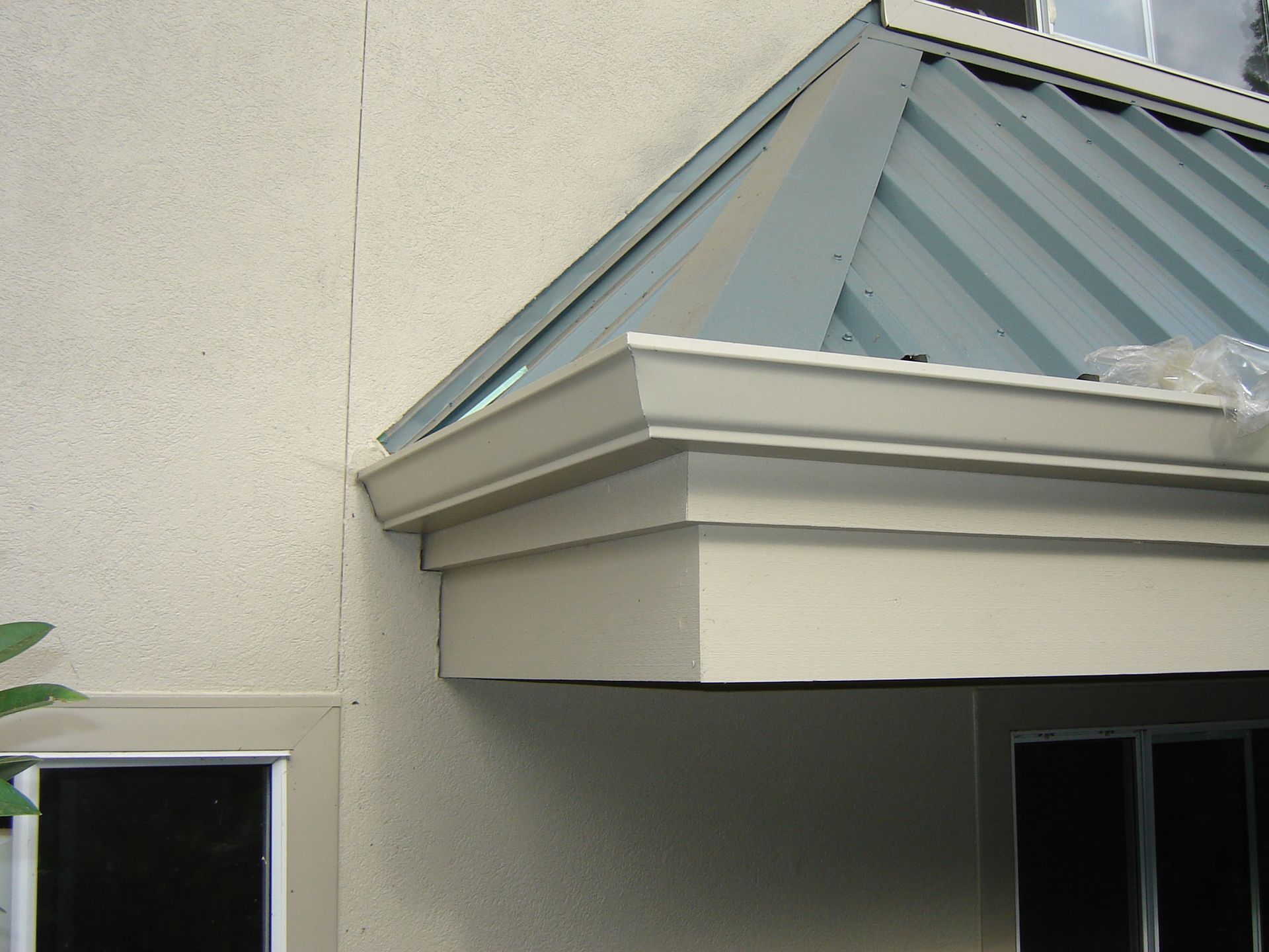 A white building with a blue roof and a window