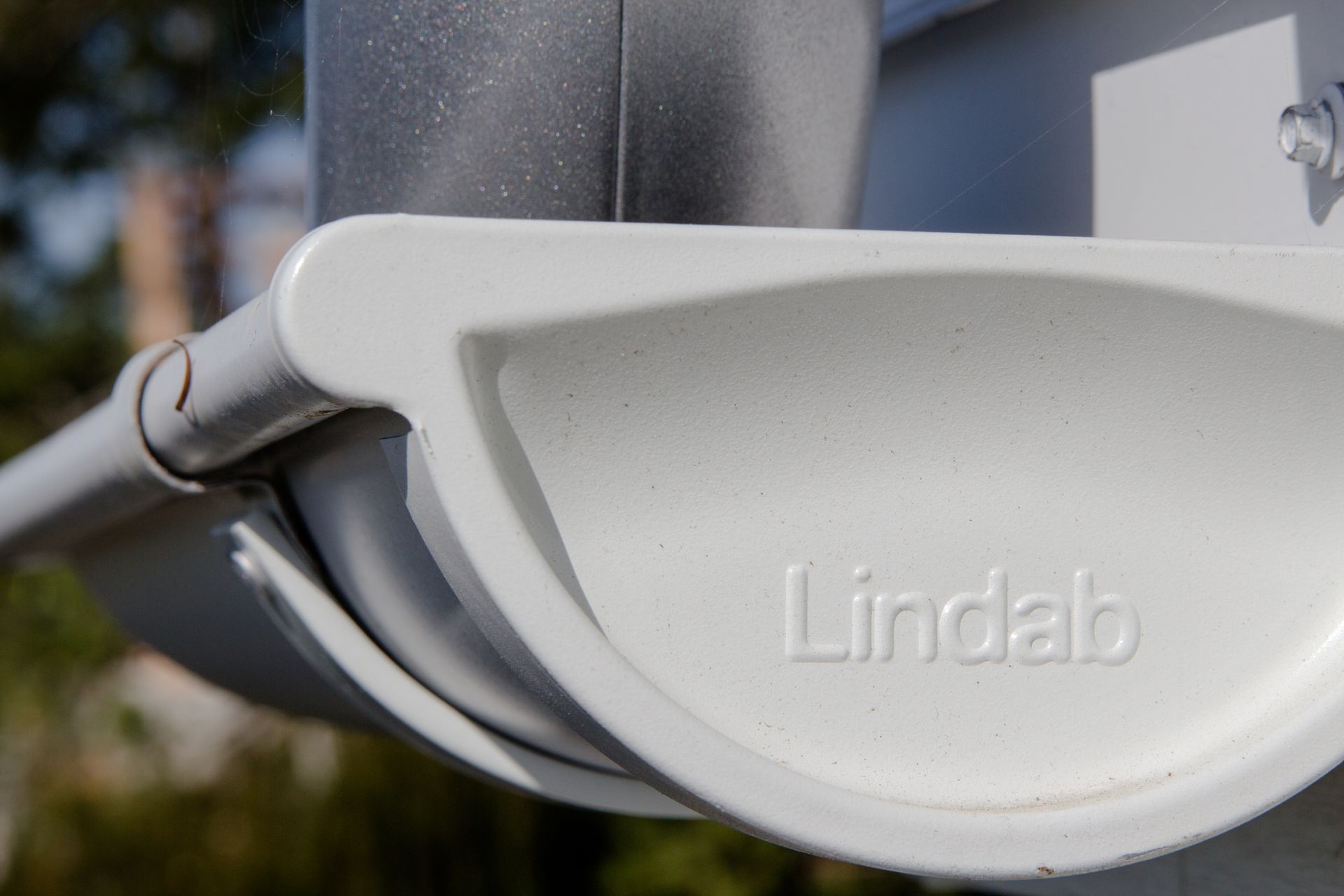 A close up of a white gutter with the word lindab written on it.