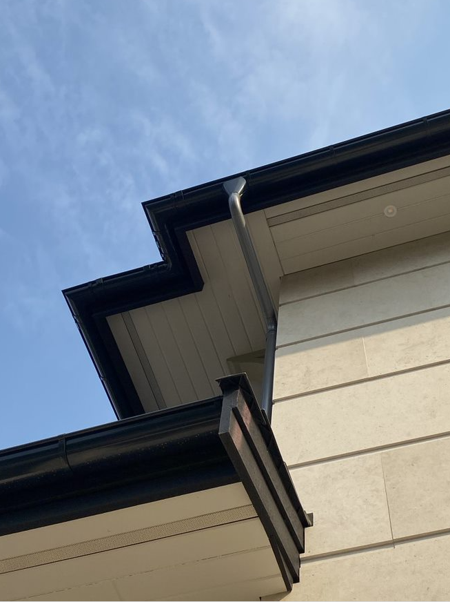 Looking up at the roof of a house with a blue sky in the background