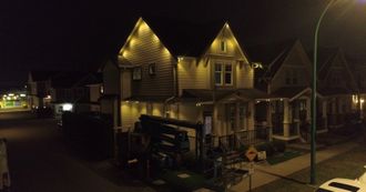 A row of houses are lit up at night in a residential area