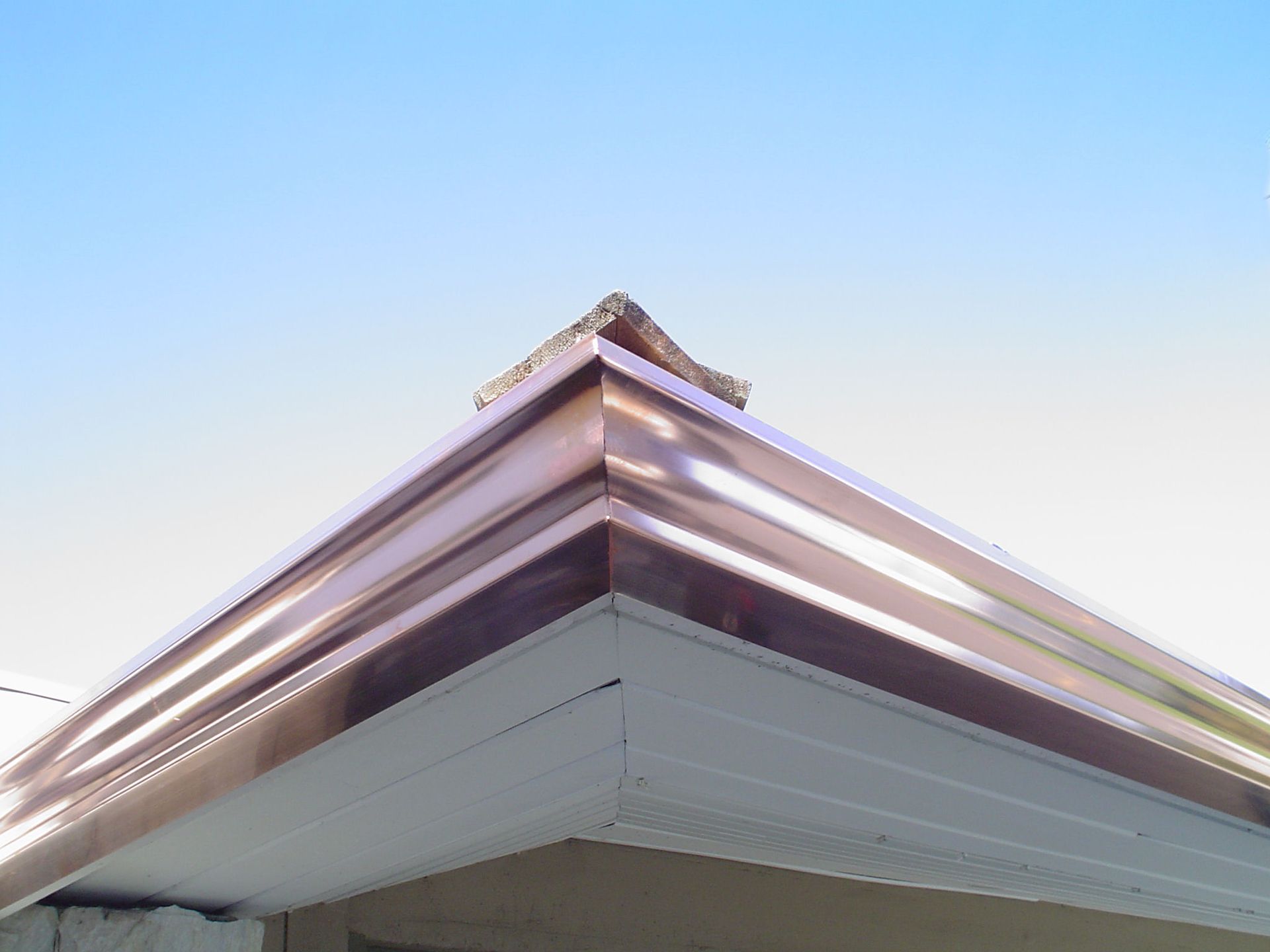 A copper gutter on the corner of a house