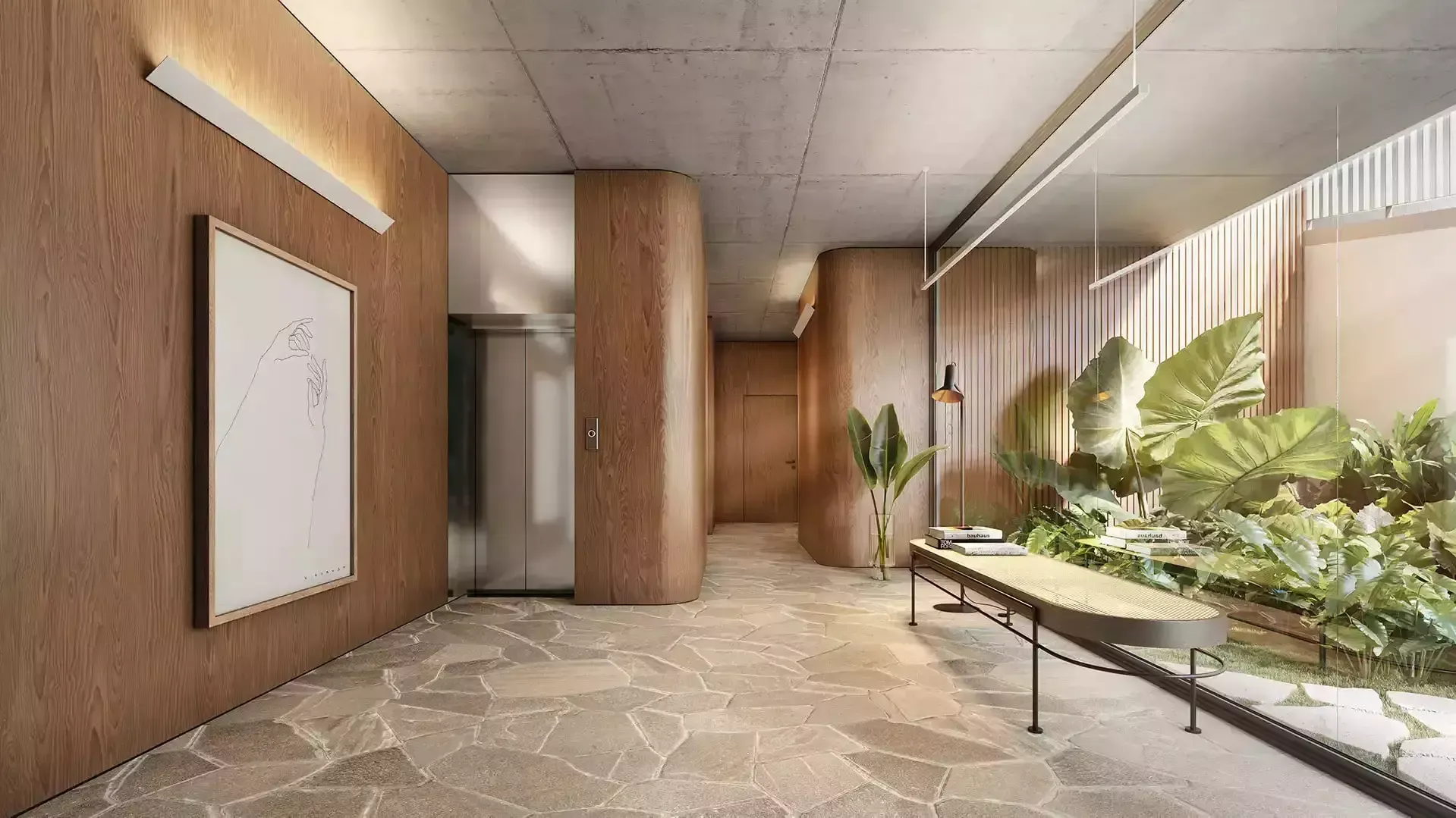 Corredor com paredes texturizadas em tom marrom, elevador, plantas grandes, banco e piso de pedra.