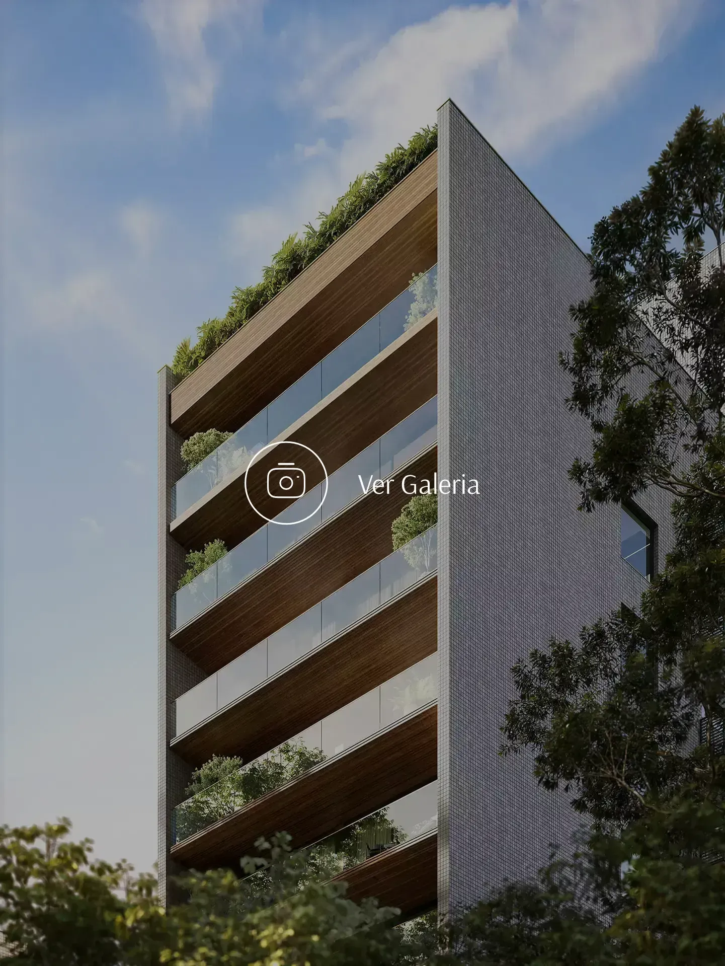 Prédio moderno com varandas e área verde em um dia ensolarado.