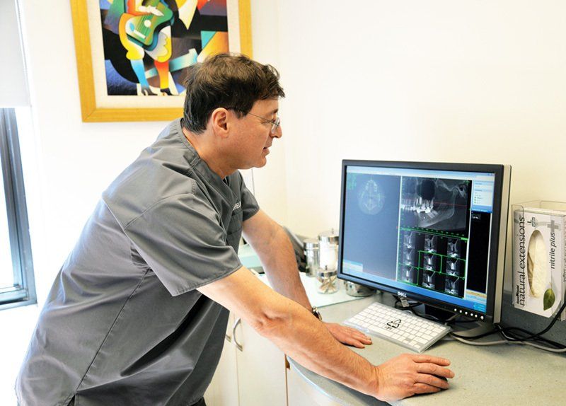 Dr. Mark reviews a post surgical CT scan of a patient to confirm proper placement of implants.