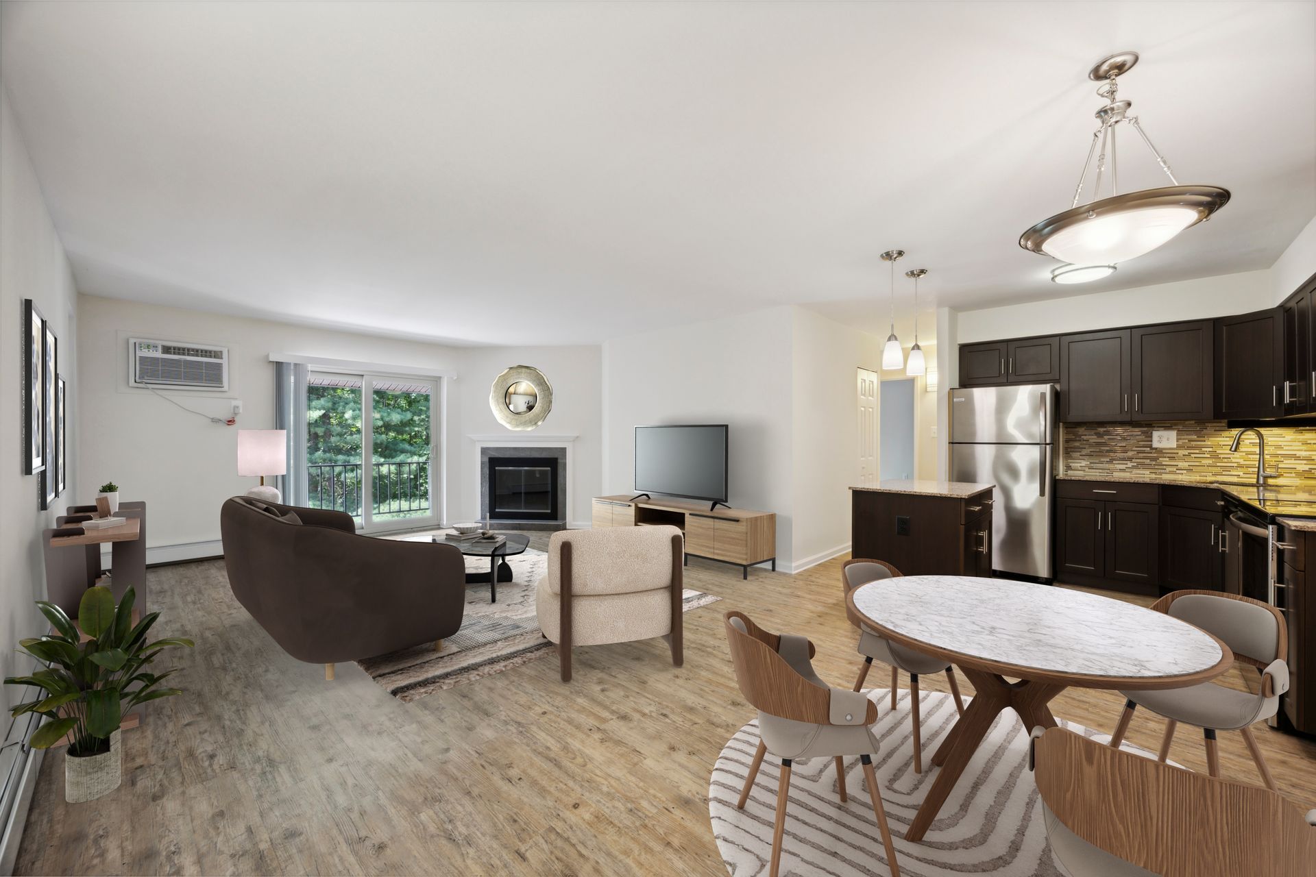 Open-concept living space with kitchen, living room, and dining area. Brown cabinets, stainless steel appliances, and wood floors.