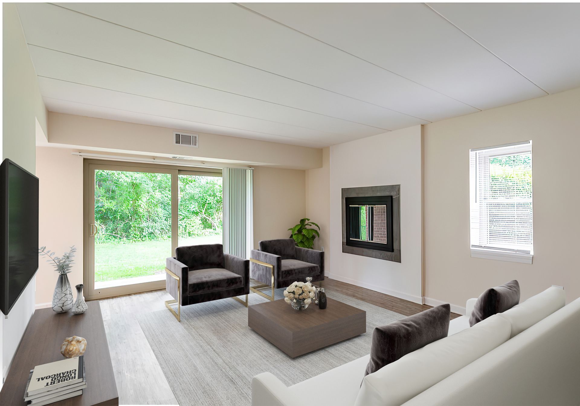Living room with sliding door to a yard, neutral tones, fireplace, two armchairs, a sofa, and television.