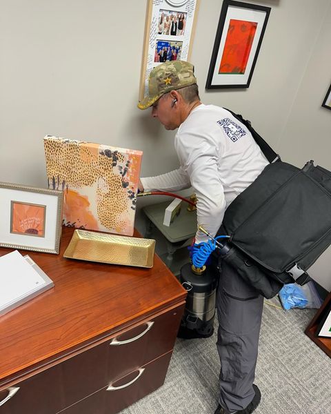 Person examining desk with gold bar, possibly looking for something. Office setting.