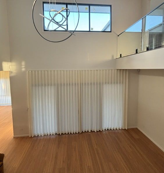 A Tall Light-Filled Room with Large Cream-Colored Curtains Covering a Window — U Curtains in Acacia Ridge, QLD