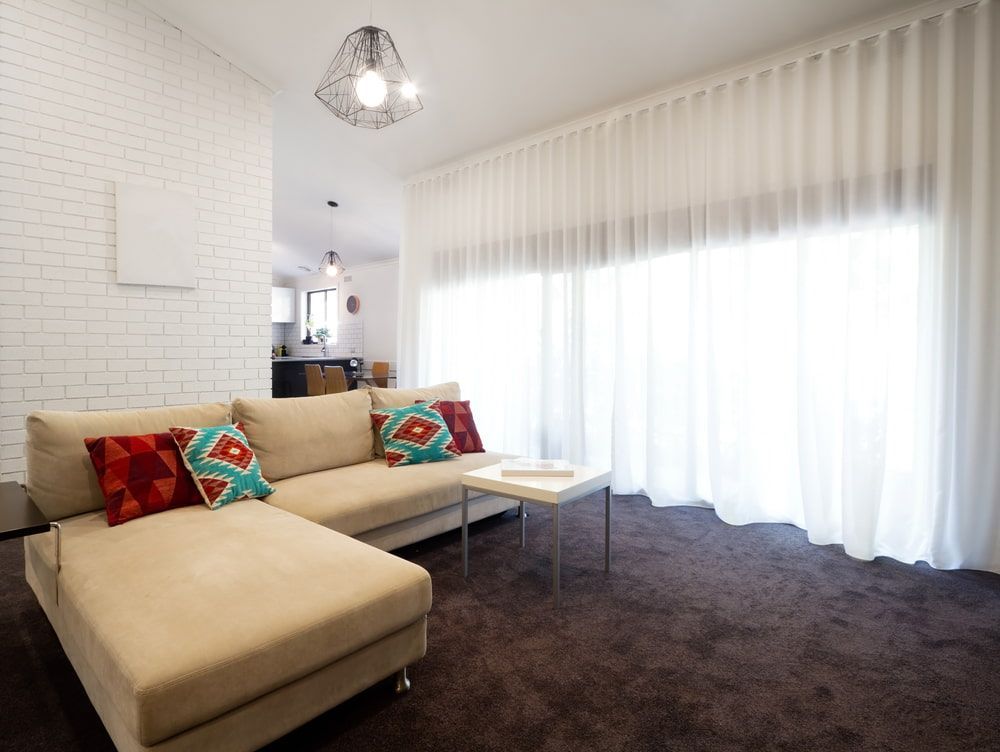 Beige Sectional Sofa with Colorful Pillows in A Modern Living Room with Sheer White Curtains — U Curtains in Acacia Ridge, QLD