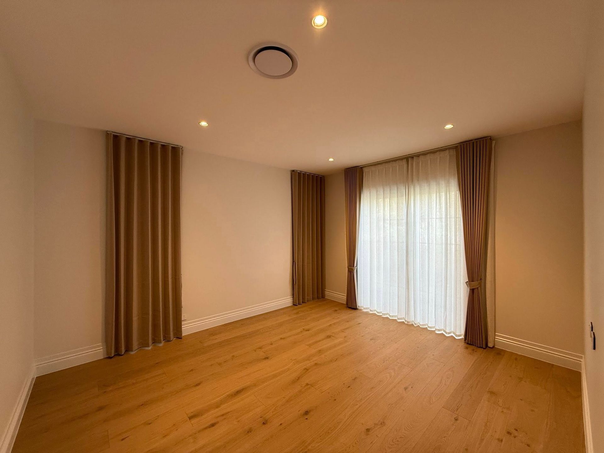 Living Room with Blue Curtains Framing a Large Window, Light-Colored Walls and A Grey Sofa — U Curtains in Acacia Ridge, QLD