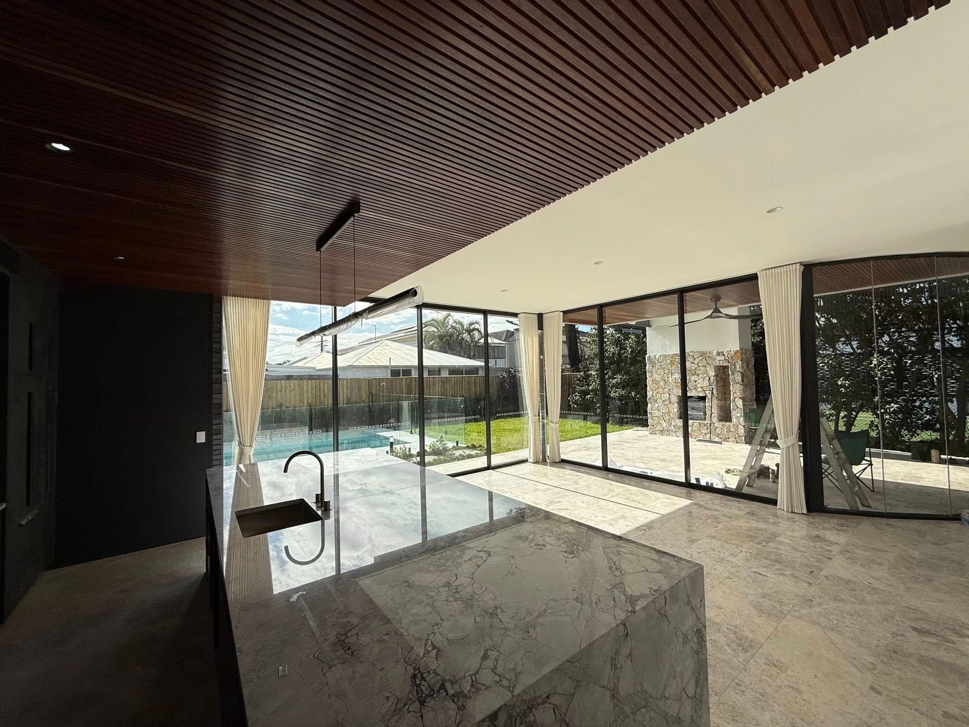 A Modern Living Room with A Large Curved Window Featuring Blue, Yellow and White Curtains — U Curtains in Acacia Ridge, QLD
