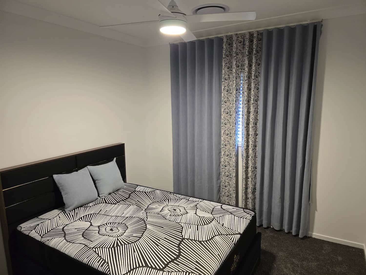 Bedroom with A Black Bed, Patterned Comforter and Gray Curtains — U Curtains in Acacia Ridge, QLD