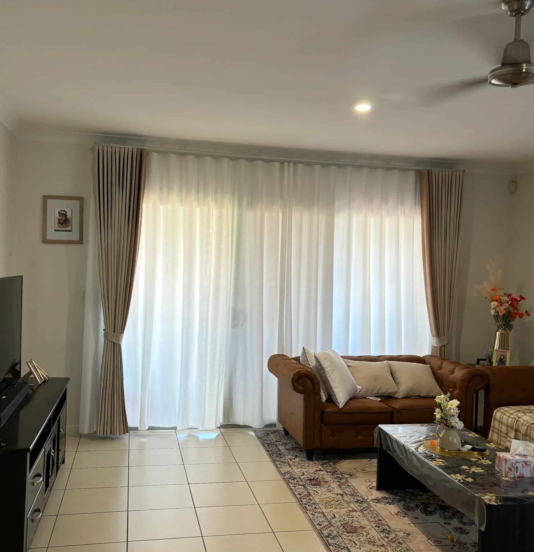 Living Room with A Brown Leather Sofa, Sheer White Curtains and A Dark Wood Coffee Table — U Curtains in Acacia Ridge, QLD