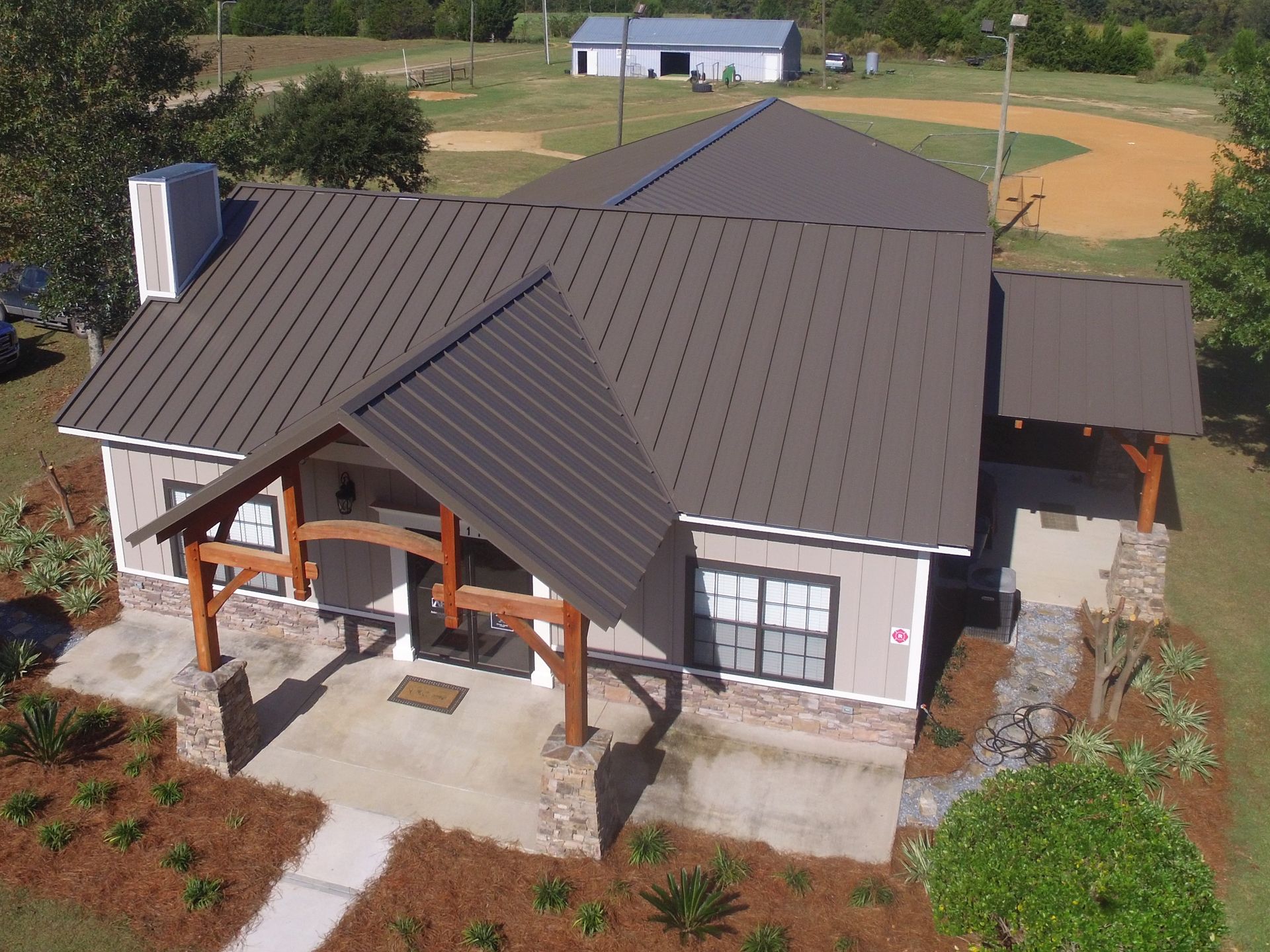 An aerial view of a house with a copper roof and a car parked in front of it.