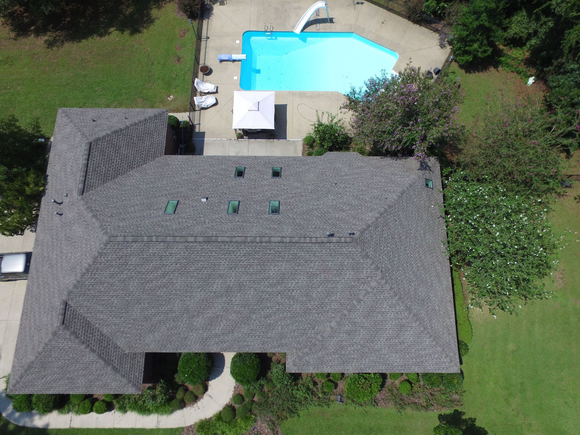 An aerial view of a house with a pool in the backyard