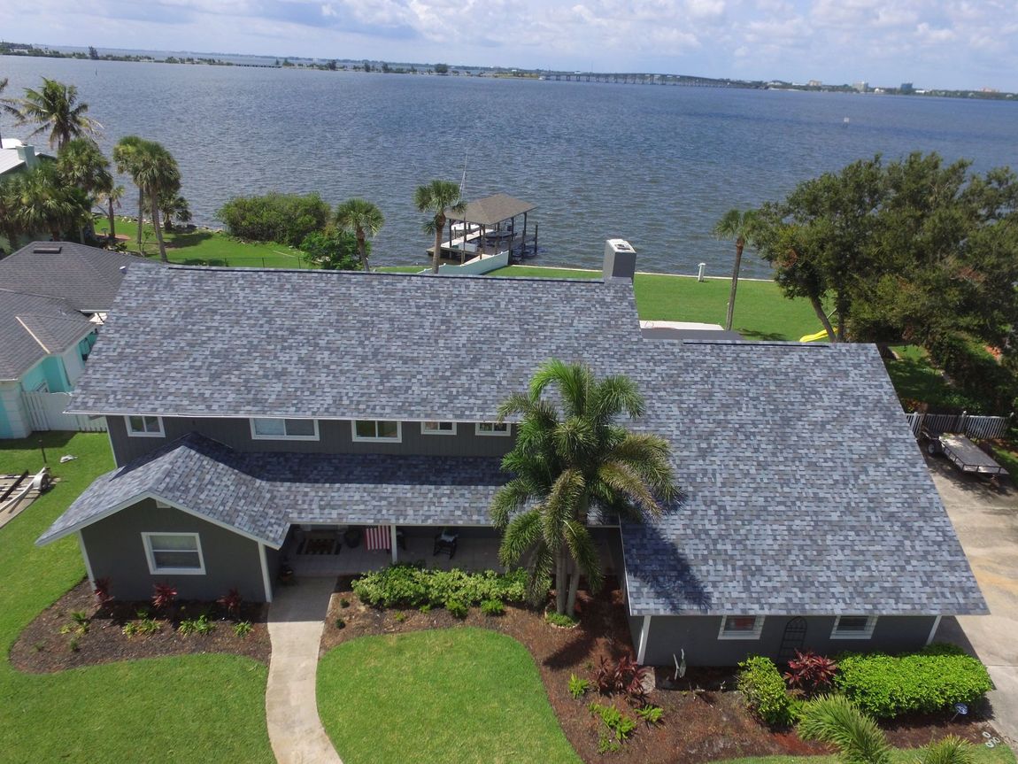 An aerial view of a house next to a body of water.