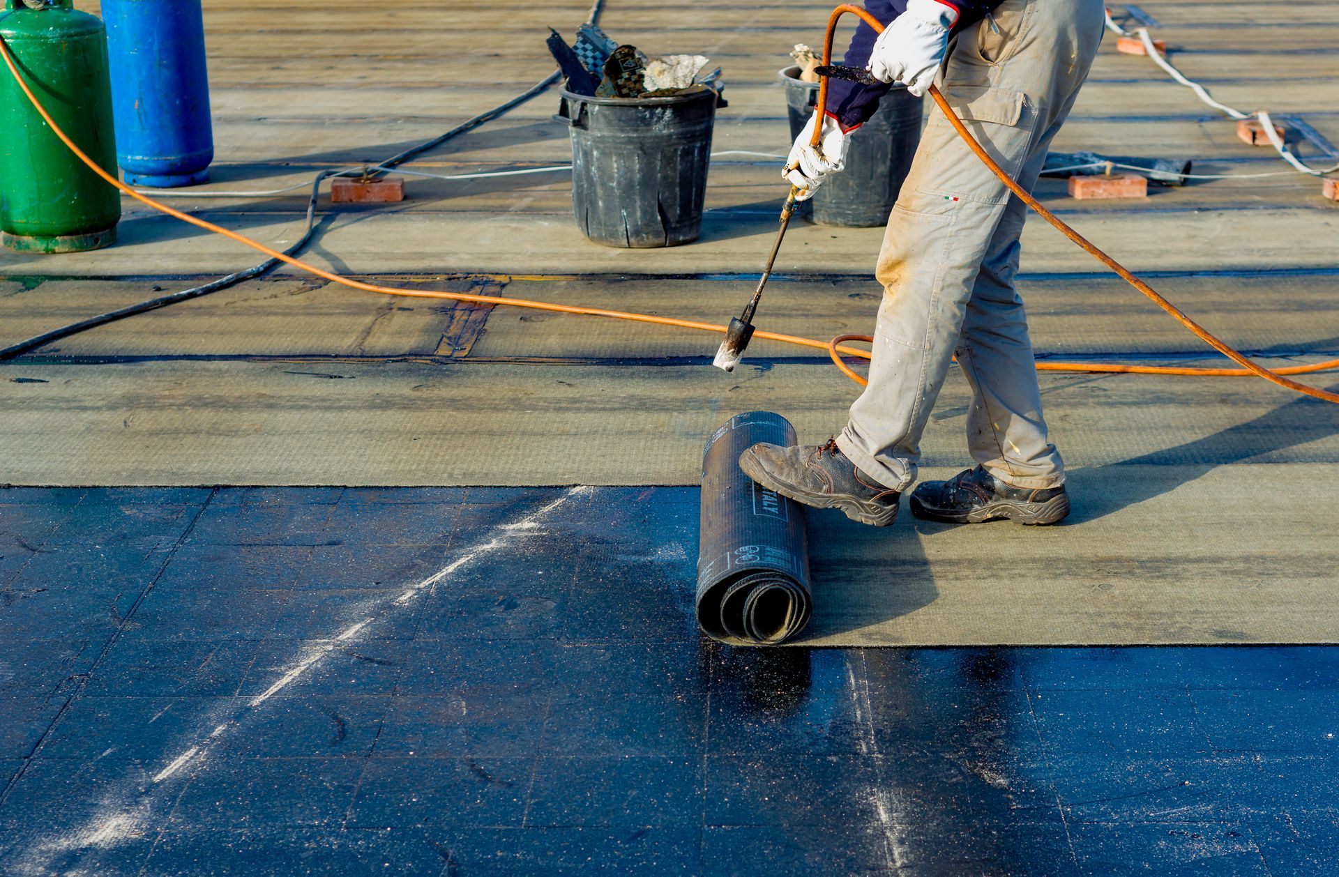 A man is working on a roof with a torch.