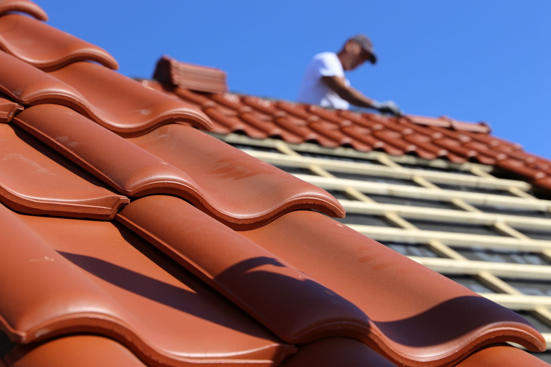 A man is working on the roof of a house