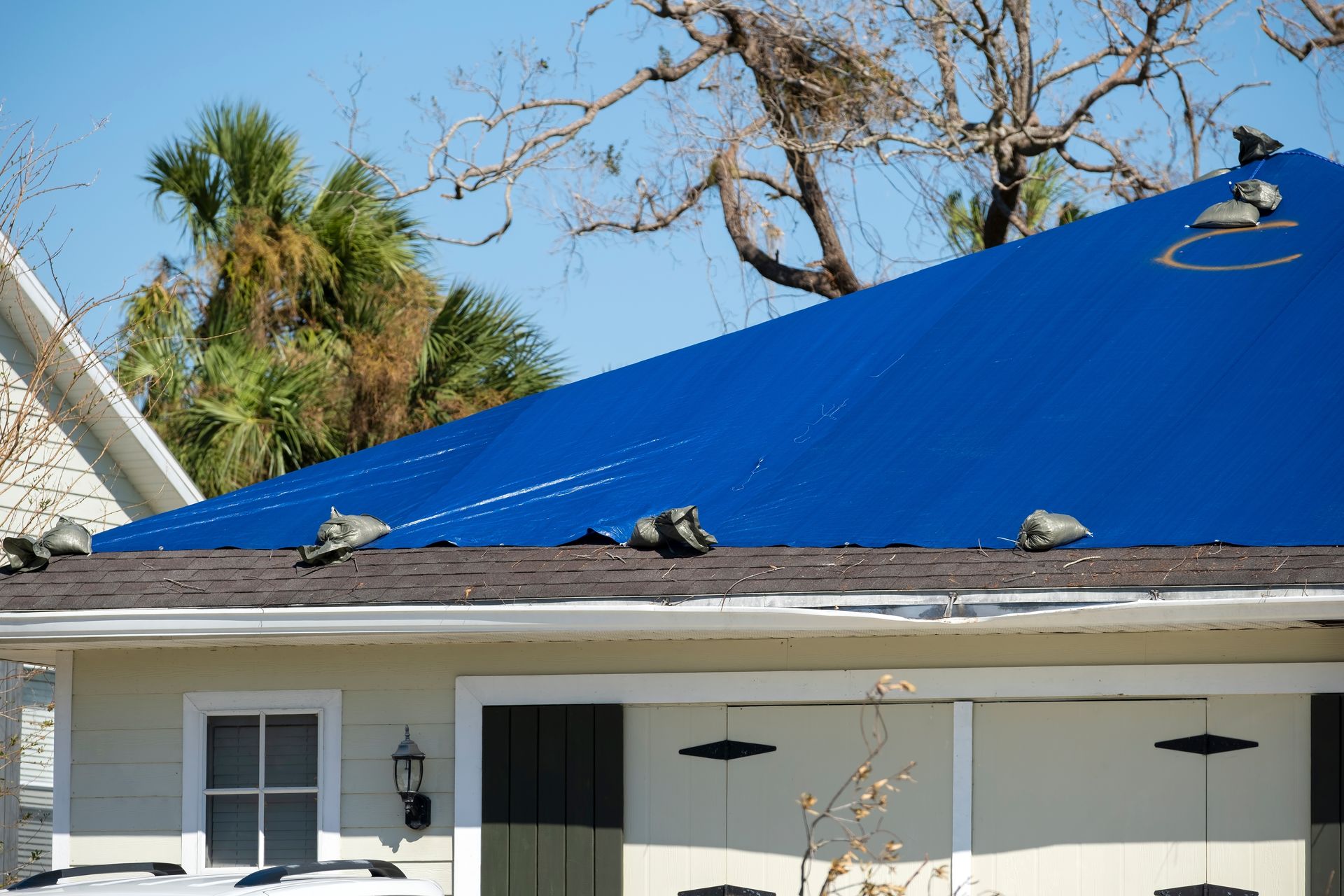 A man is installing shingles on a roof.