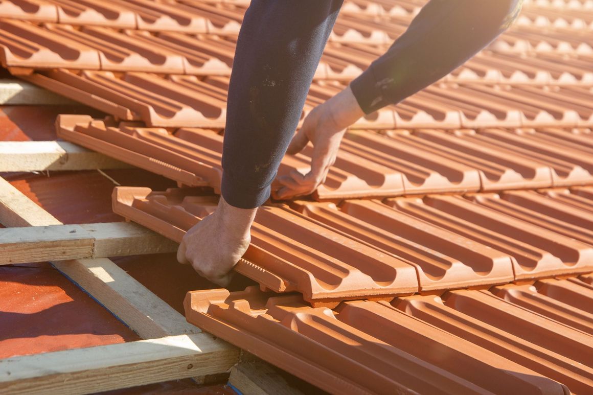 A person is installing tiles on a roof.