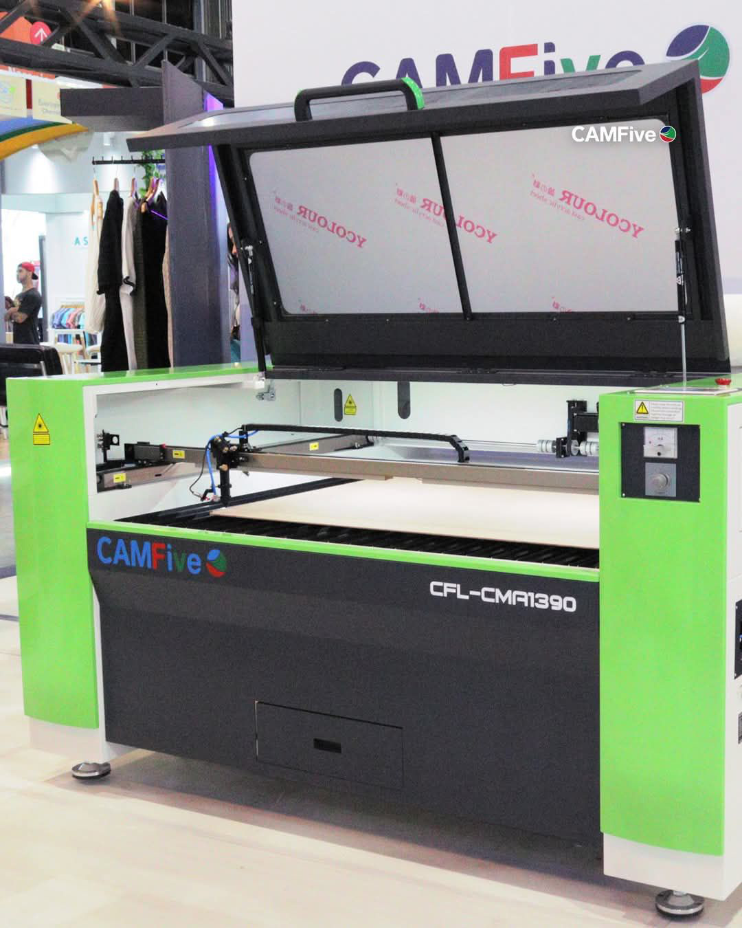 Una gran máquina de corte láser CAMFive verde y negra con la tapa abierta, lista para usar en un taller.