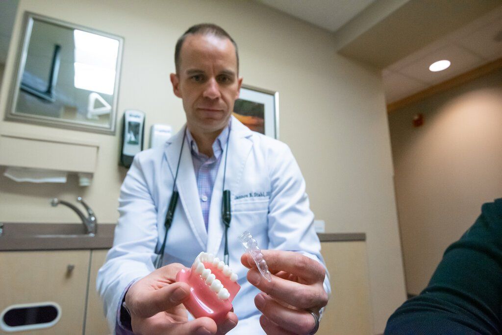 dentist showing a patient Invisalign 