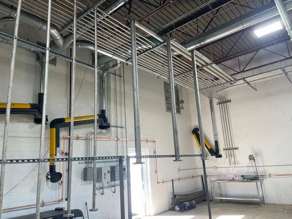 A room with a lot of pipes hanging from the ceiling