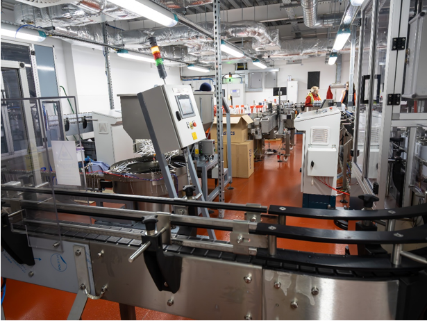 A man is pressing a button on a control panel in a factory.