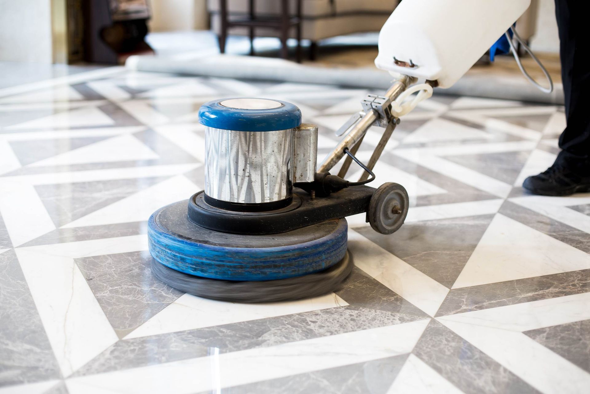 A person is using a machine to clean a marble floor