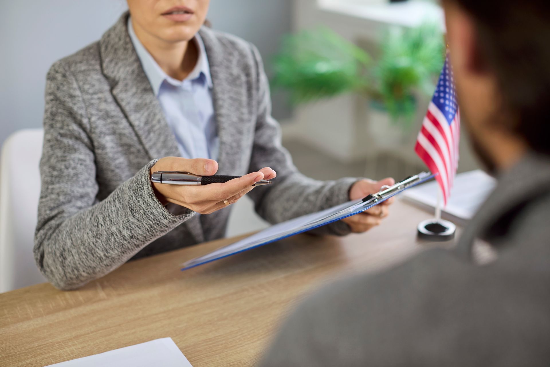 Immigration lawyer discussing paperwork for D.a.p.a. cases at office desk with American flag.