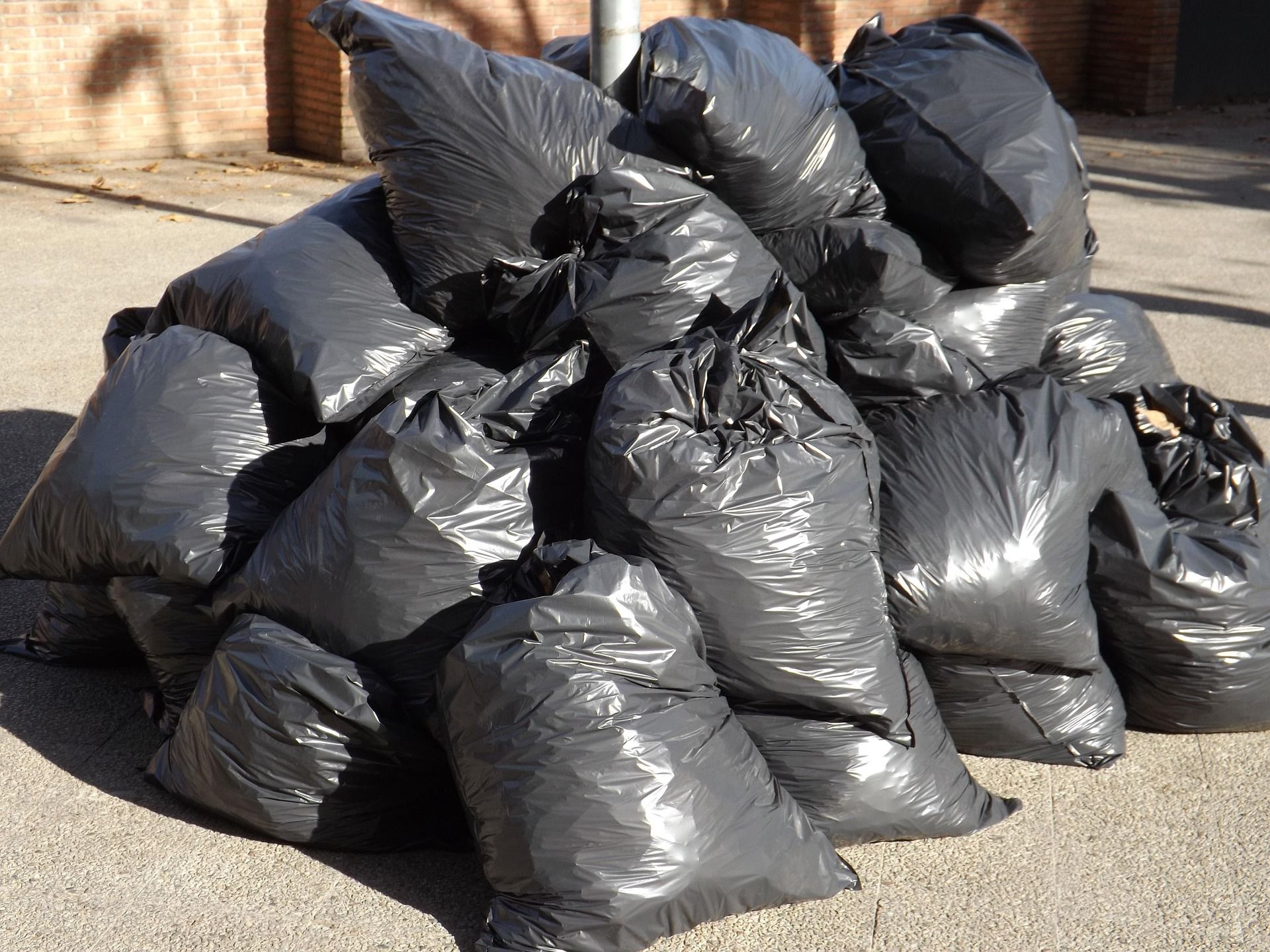 Contractor trash bags filled with junk on the ground