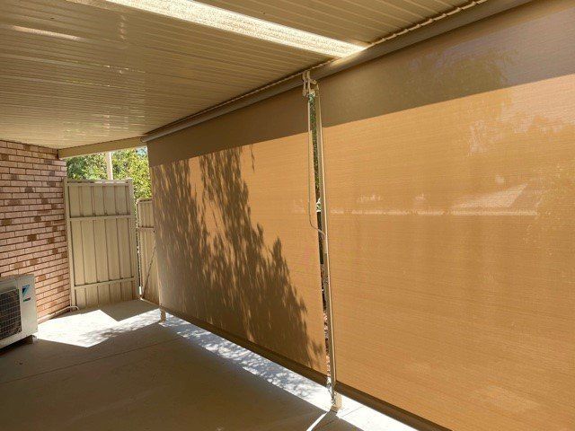 Beige Outdoor Roller Blinds on A Patio Casting Tree Shadows — Alice Mobile Blinds in Ciccone, NT
