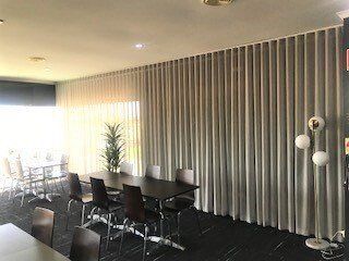 Dining Room with Dark Table, Chairs and Long Grey Curtains — Alice Mobile Blinds in Ciccone, NT