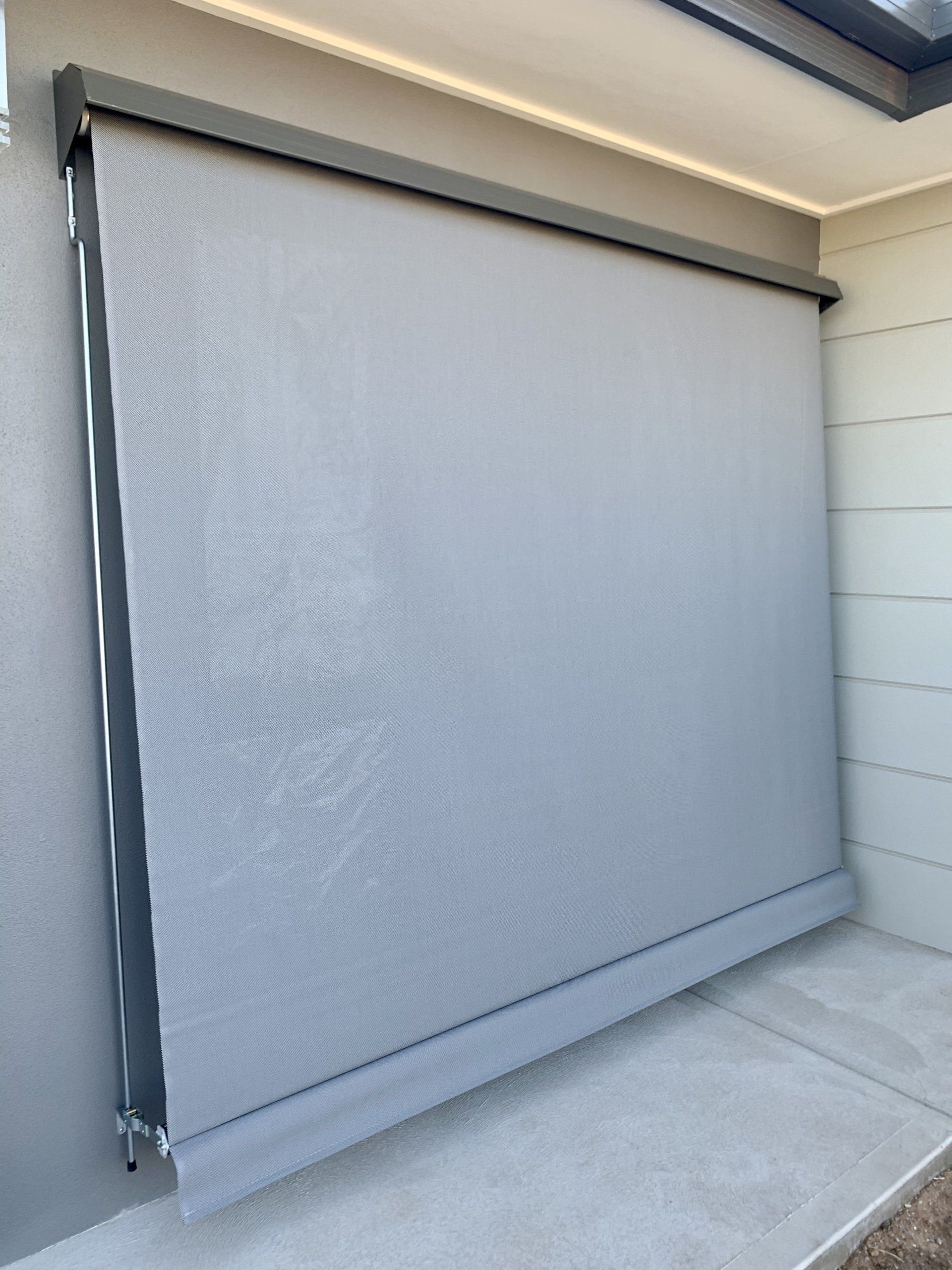 Grey Outdoor Roller Shade Covering a Doorway or Window — Alice Mobile Blinds in Ciccone, NT