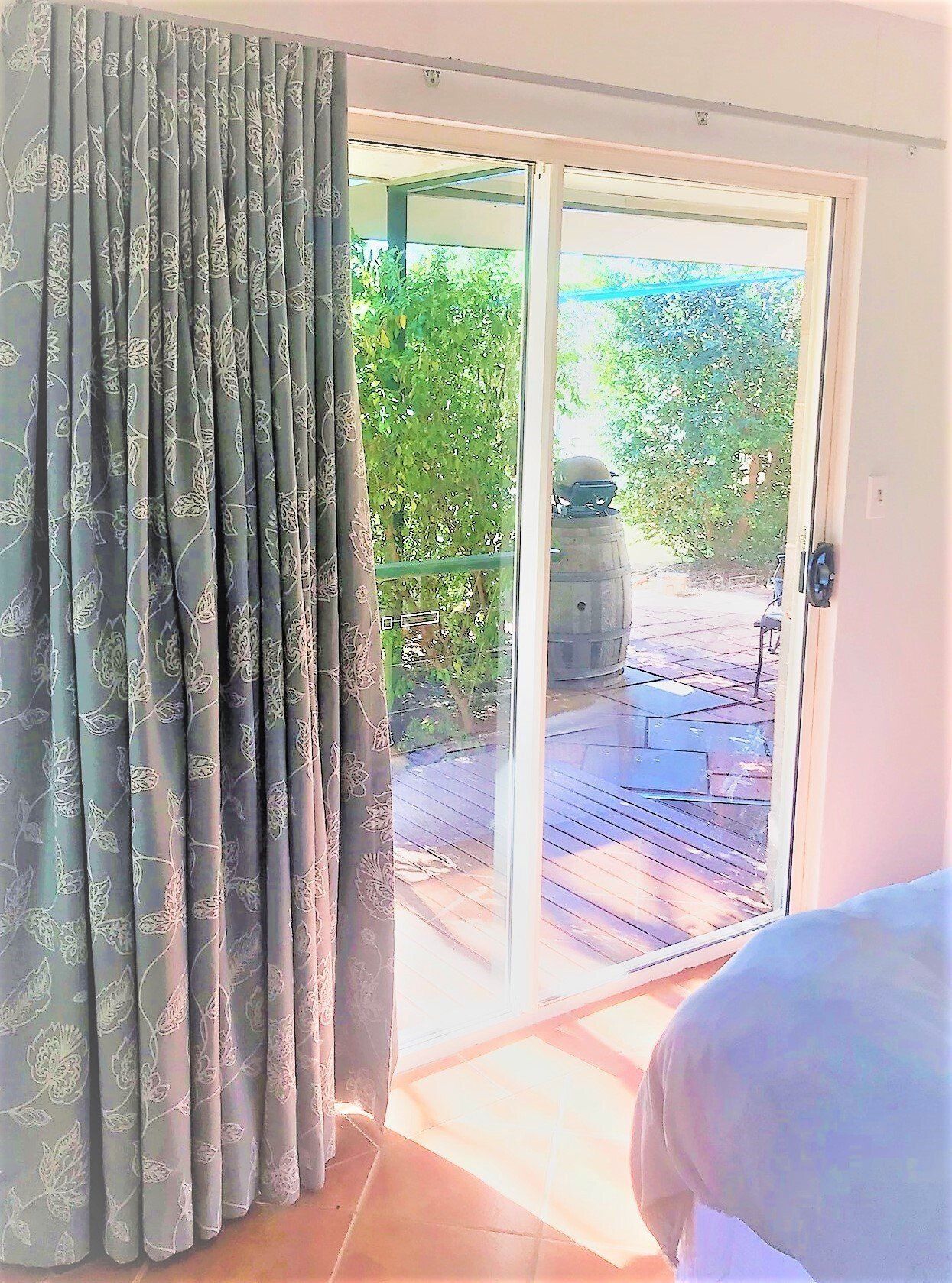 Blue Patterned Curtain Next to A Sliding Glass Door — Alice Mobile Blinds in Ciccone, NT