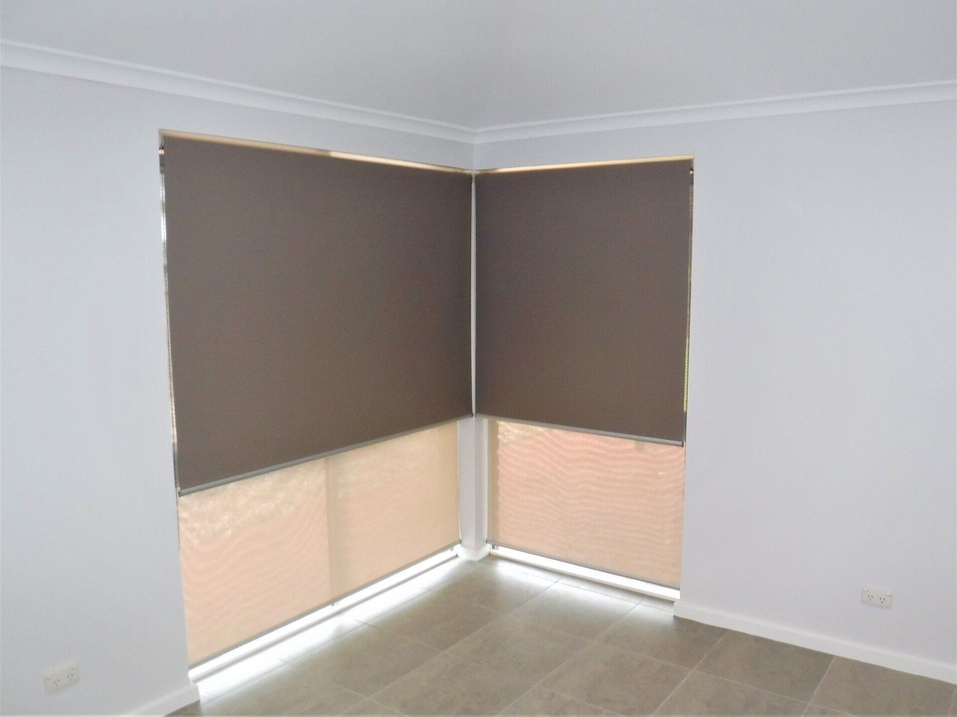 Corner Windows with Brown Roller Shades and Beige Blinds — Alice Mobile Blinds in Ciccone, NT
