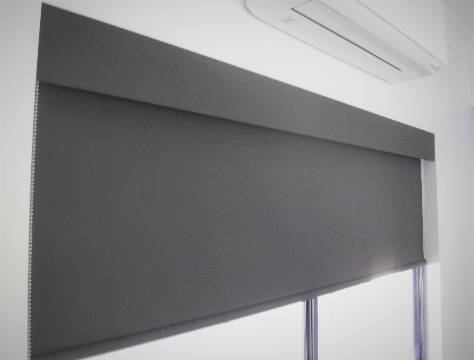 Dark Grey Roller Shade on A Window — Alice Mobile Blinds in Ciccone, NT