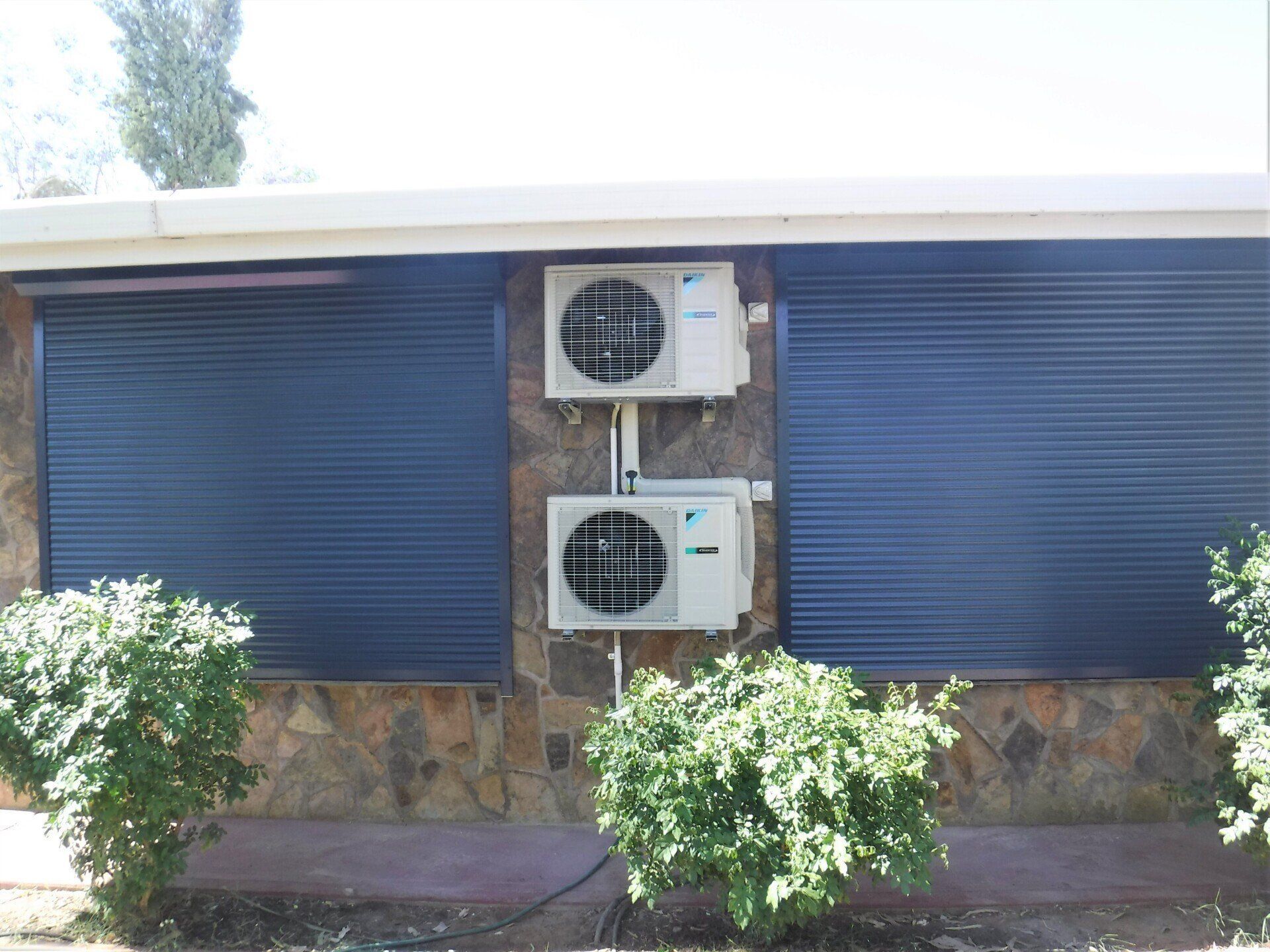 Exterior of Building with Two Blue Shutters — Alice Mobile Blinds in Ciccone, NT