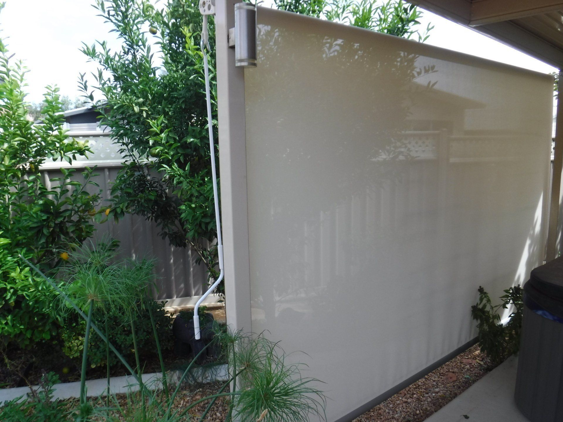 Beige Outdoor Shade Partially Drawn Attached to A White Frame — Alice Mobile Blinds in Ciccone, NT