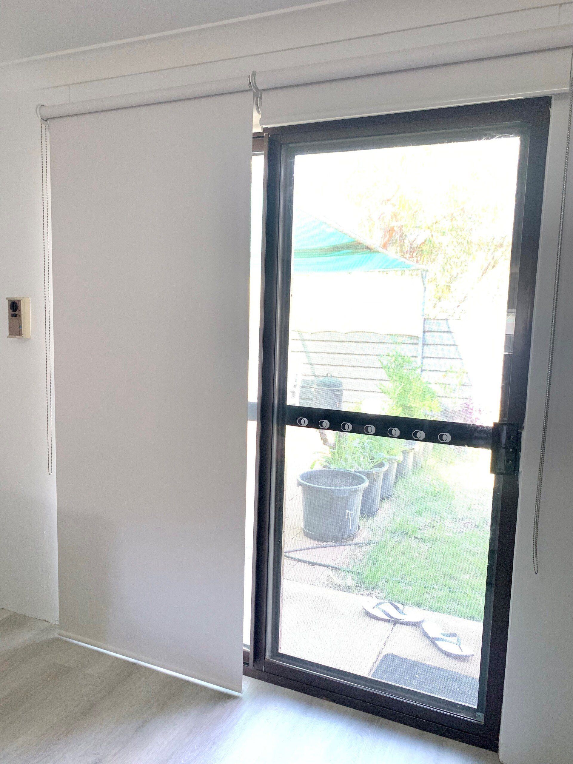 White Panel Blind Partially Covers a Sliding Glass Door — Alice Mobile Blinds in Ciccone, NT
