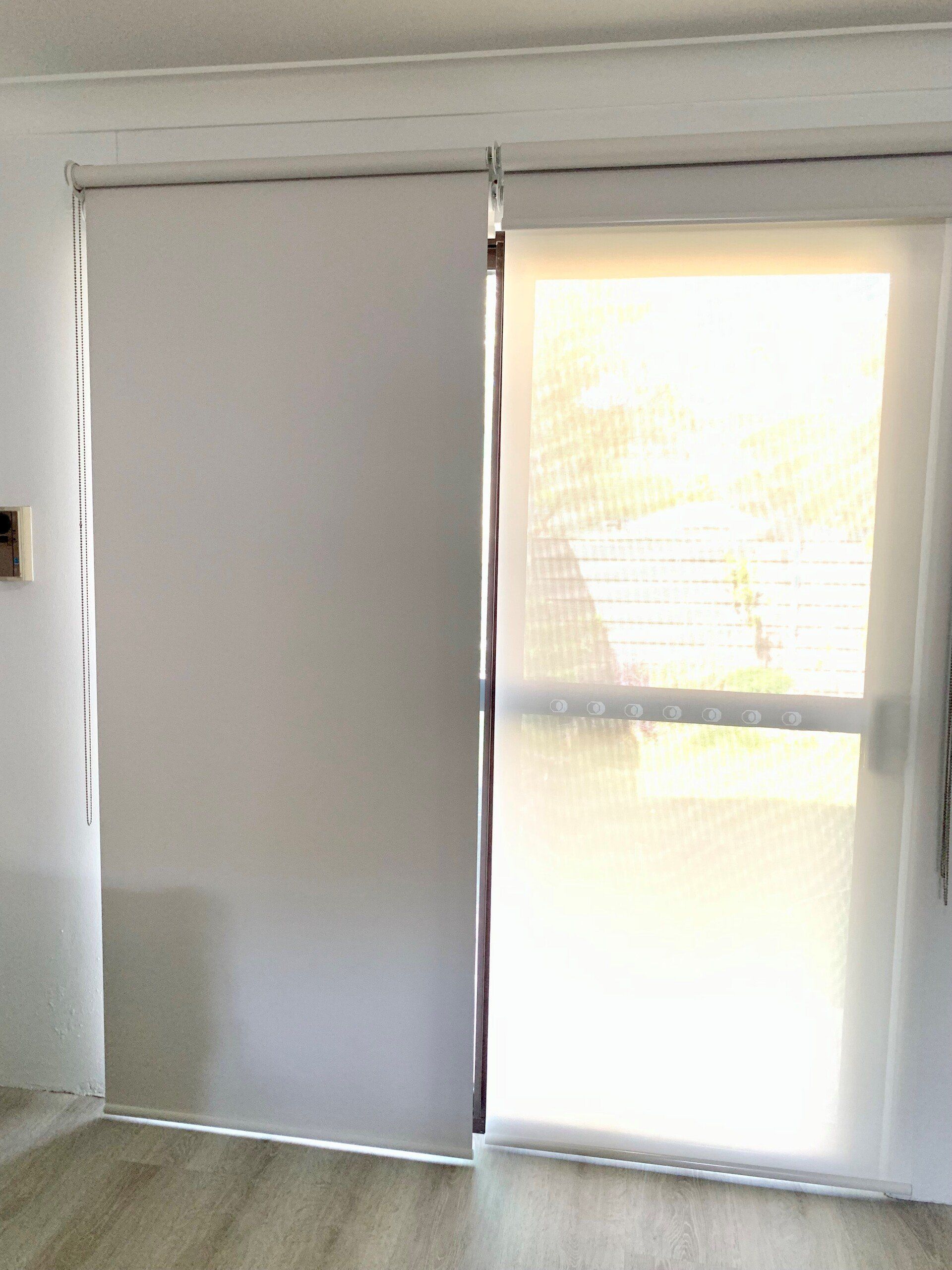 White Roller Blinds Partially Covering a Glass Door — Alice Mobile Blinds in Ciccone, NT
