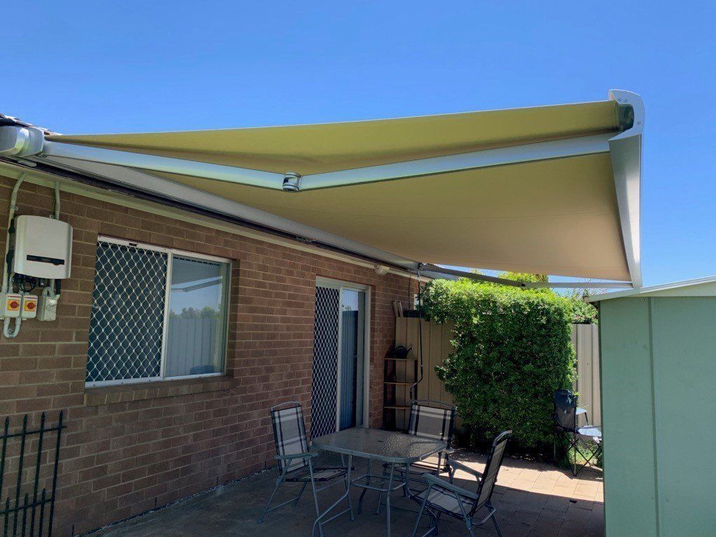 Tan Retractable Awning Over a Patio with Furniture — Alice Mobile Blinds in Ciccone, NT
